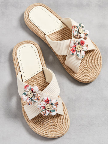 Women’s colorblock cross strap slide slippers with flower applique decor and open toe, flat sole design for beach and outdoor use.