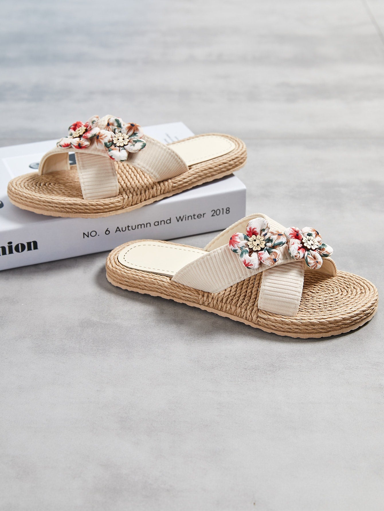 Women’s colorblock cross strap slide slippers with flower applique decor and open toe, flat sole design for beach and outdoor use.