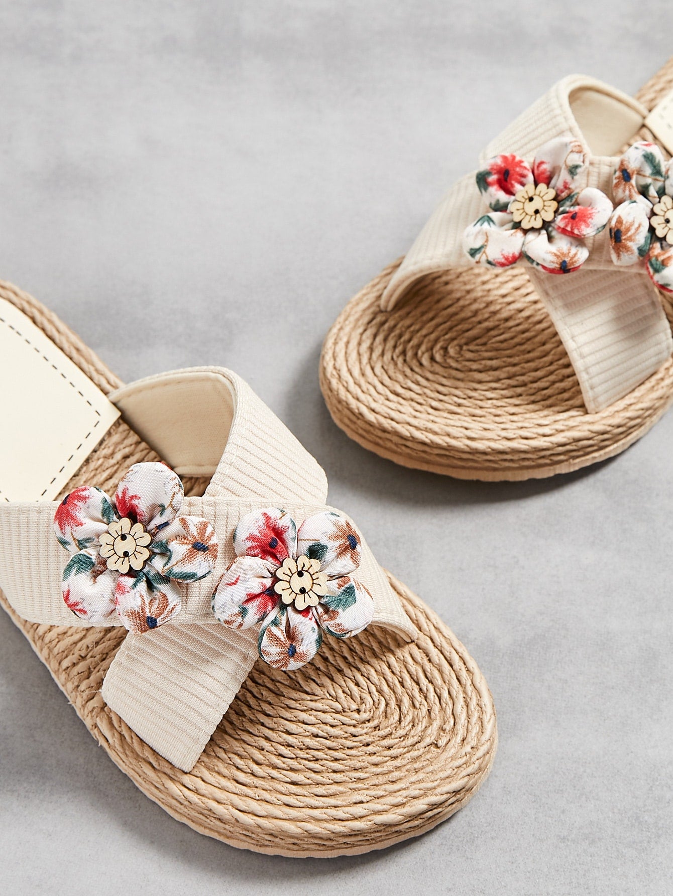Women’s colorblock cross strap slide slippers with flower applique decor and open toe, flat sole design for beach and outdoor use.