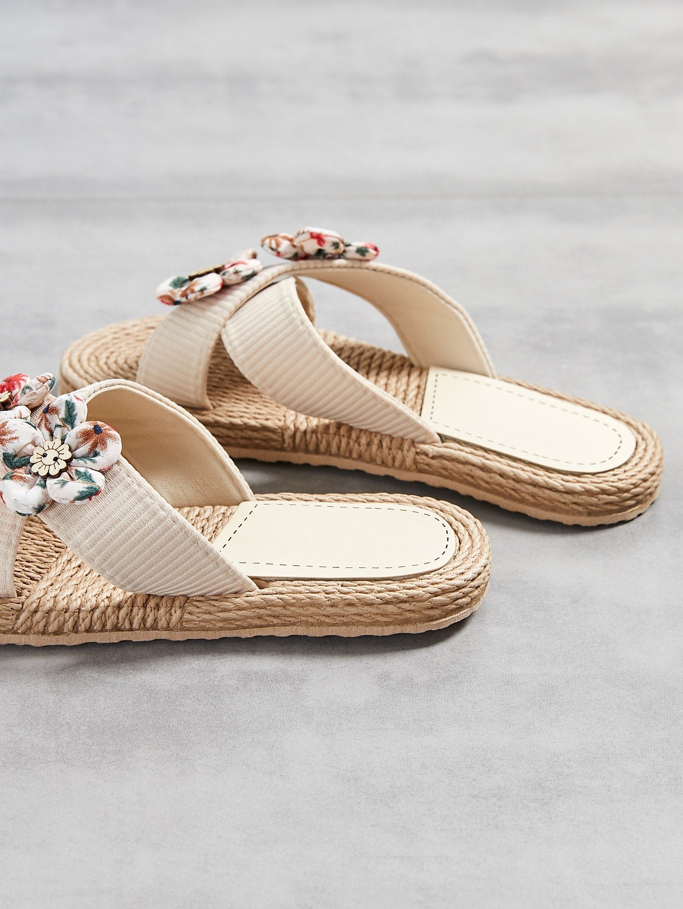 Women’s colorblock cross strap slide slippers with flower applique decor and open toe, flat sole design for beach and outdoor use.