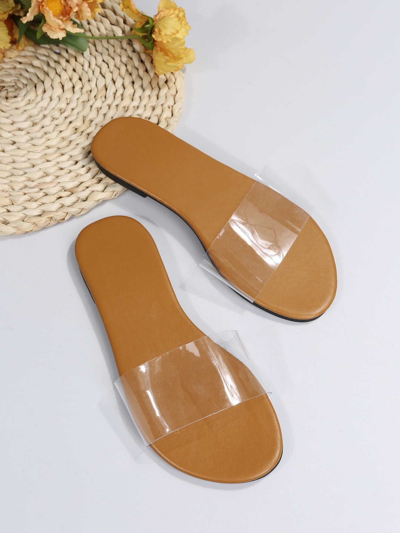 Women’s clear flat slide sandals with a single transparent band and open toe design.