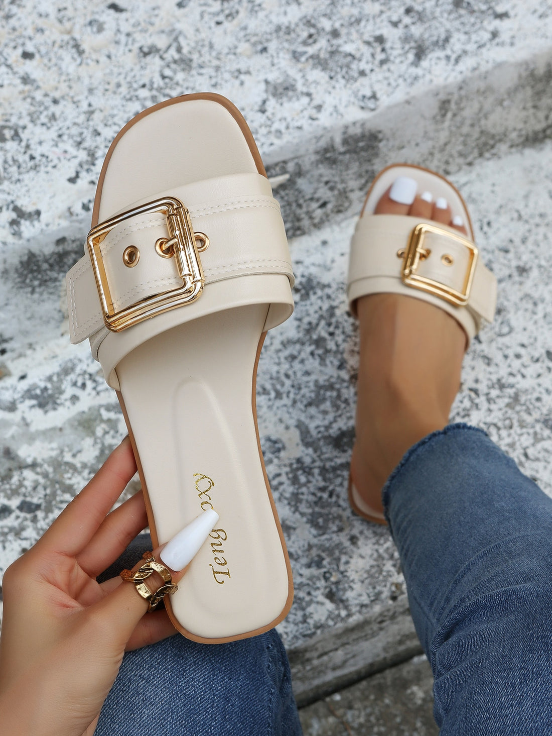 Women's beige flat slide sandals with open toe, cut-out upper, and square buckle detail, suitable for beach and summer outdoor wear.