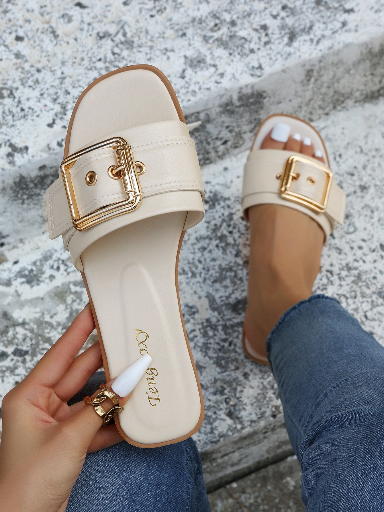 Women's beige flat slide sandals with open toe, cut-out upper, and square buckle detail, suitable for beach and summer outdoor wear.