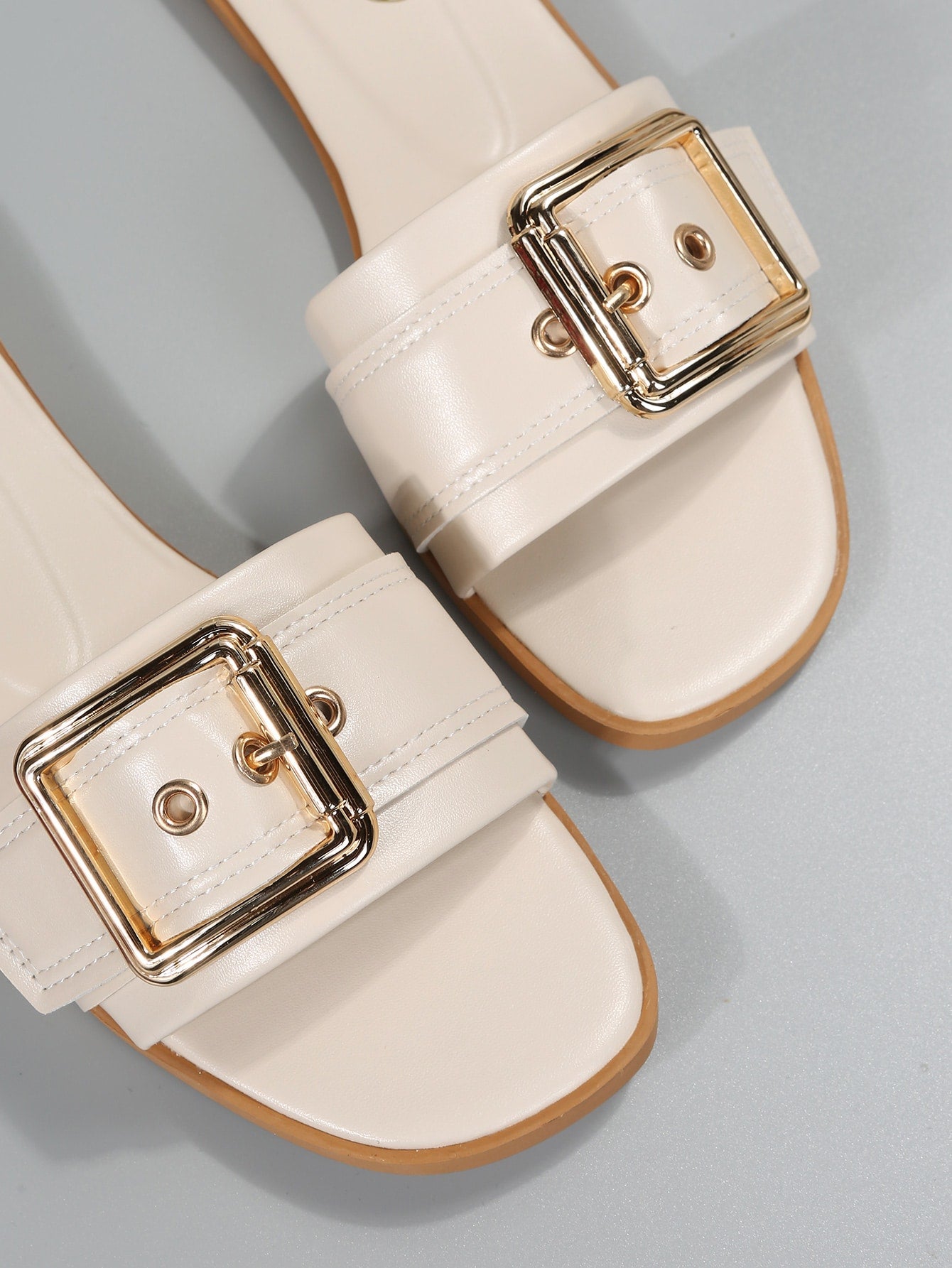 Women's beige flat slide sandals with open toe, cut-out upper, and square buckle detail, suitable for beach and summer outdoor wear.