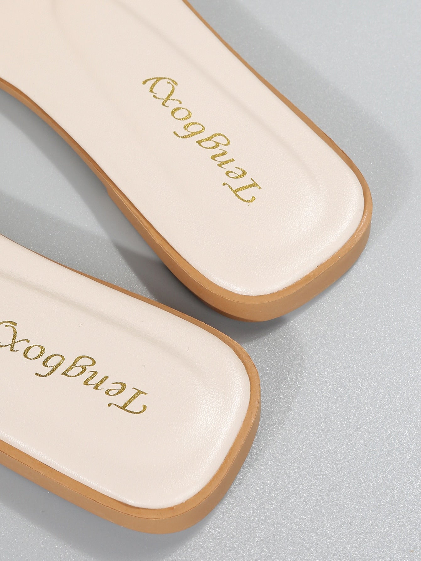 Women's beige flat slide sandals with open toe, cut-out upper, and square buckle detail, suitable for beach and summer outdoor wear.