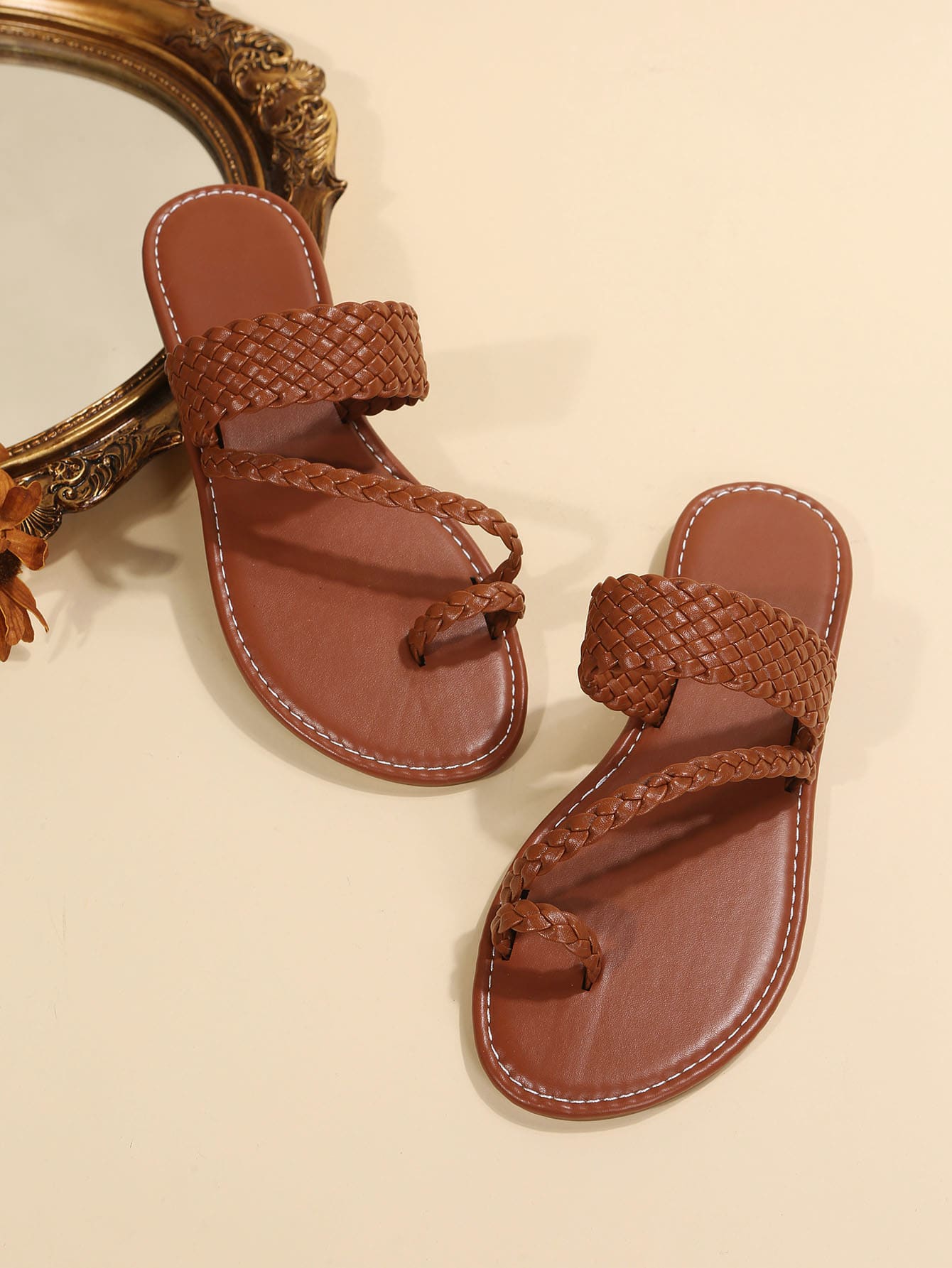 Women's brown flat thong sandals with braided straps, buckle detail, and toe post design for casual outdoor spring and summer wear.