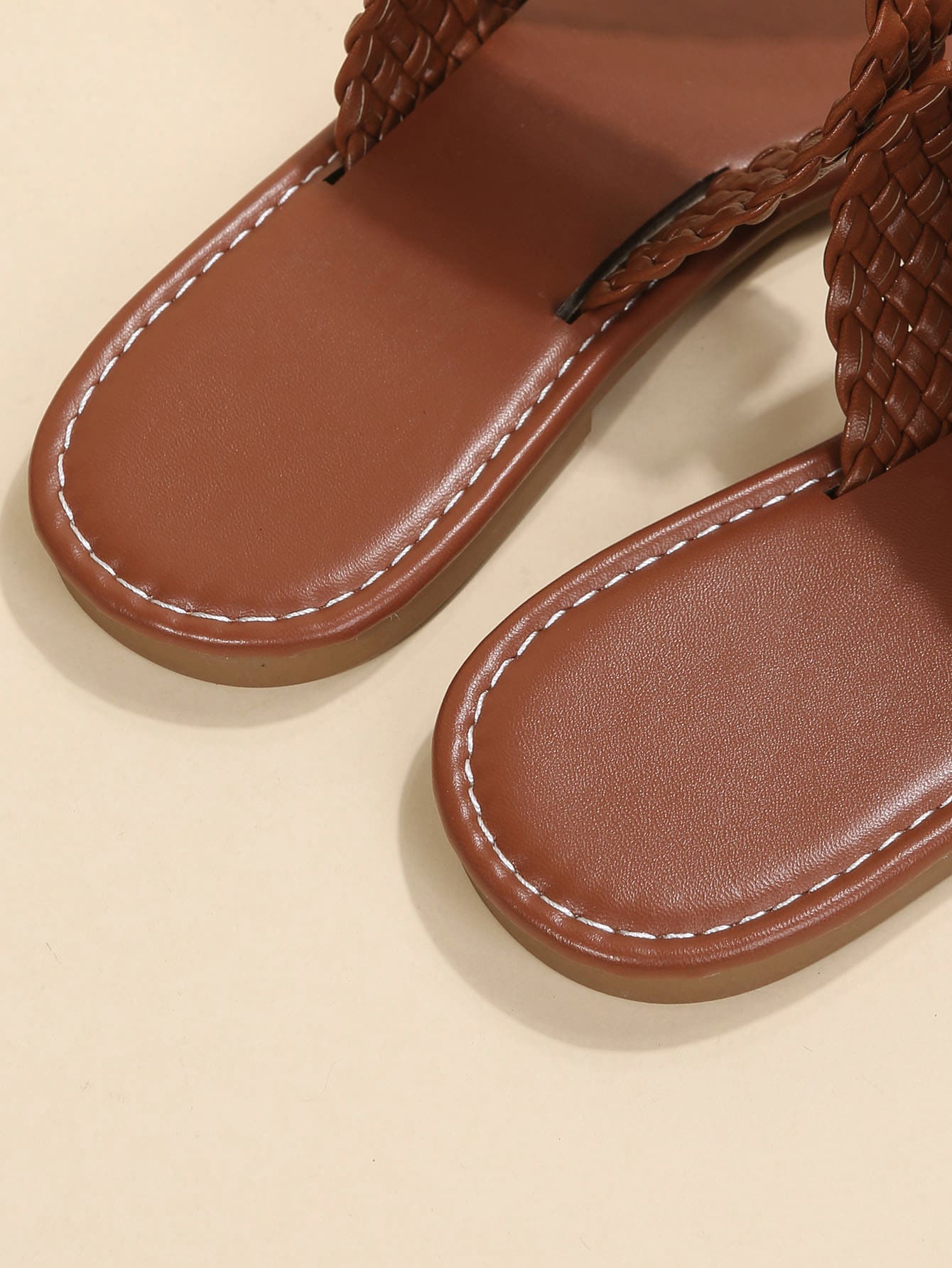 Women's brown flat thong sandals with braided straps, buckle detail, and toe post design for casual outdoor spring and summer wear.