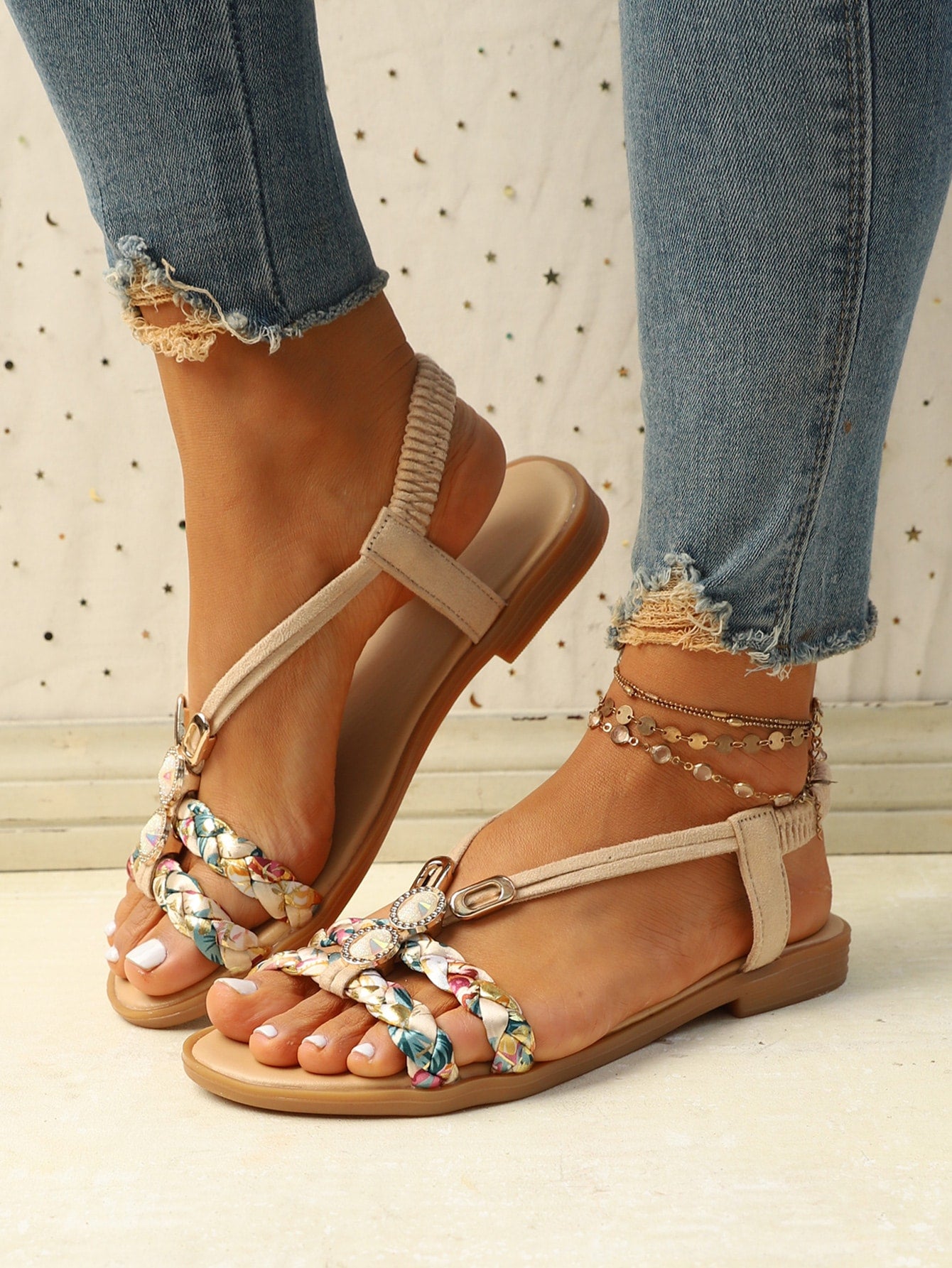 Women’s flat slingback sandals with floral pattern styling, braid detail, rhinestone accents, and open toe design