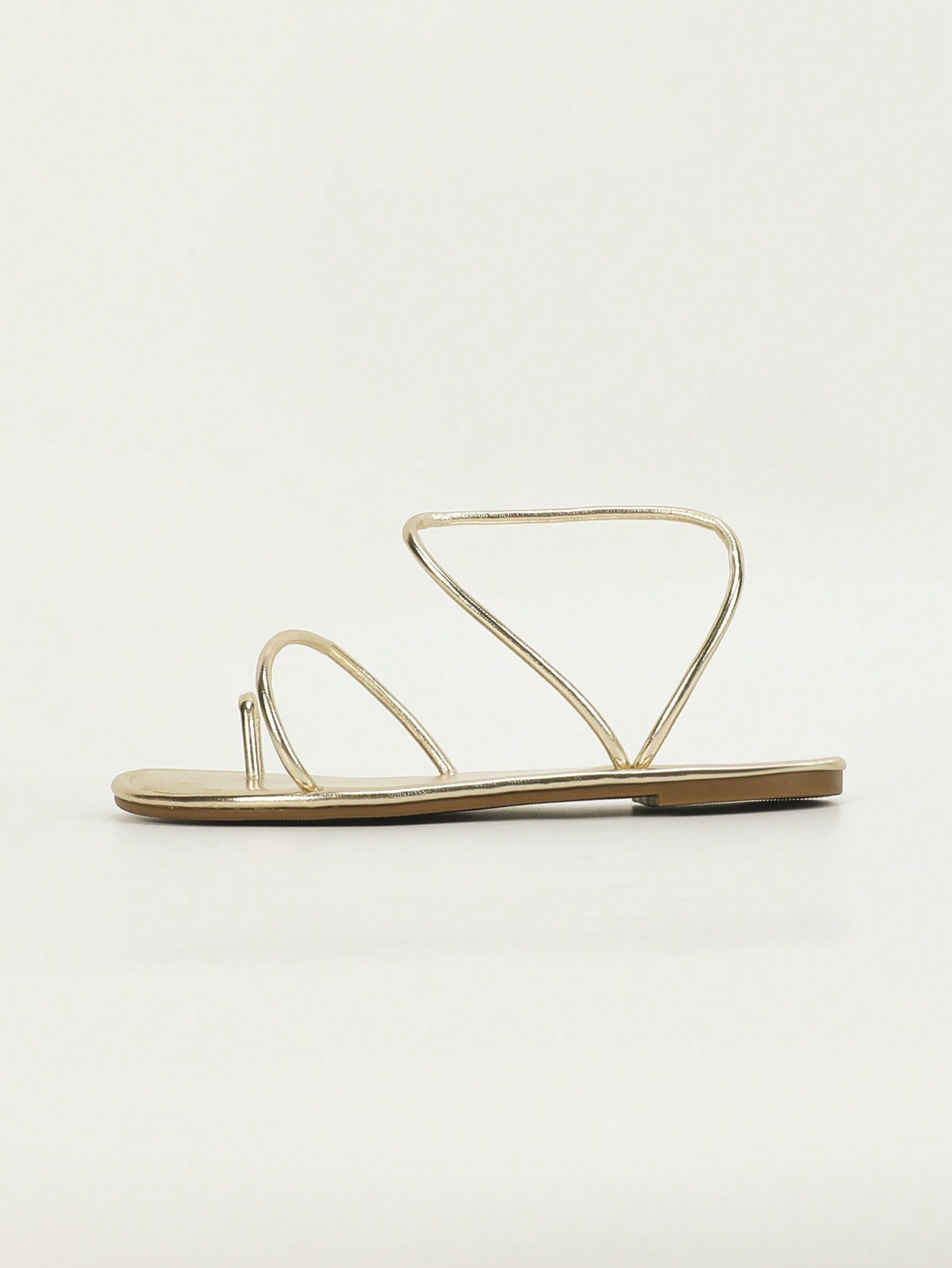 Women's gold flat bohemian gladiator sandals with criss-cross strappy design and toe post, suitable for summer vacation and beach outfits.