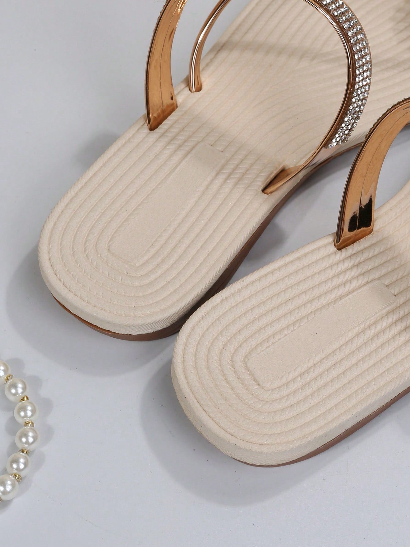 Women's casual flat sandals with slip-on criss-cross straps, toe post design, and rhinestone detail, suitable for beach and summer vacation wear.