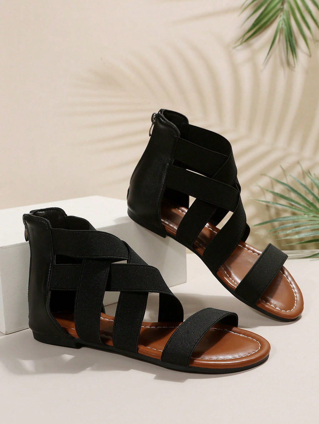 Pair of women’s floral beaded Roman style flat gladiator sandals with open toe design, suitable for beach and vacation wear.