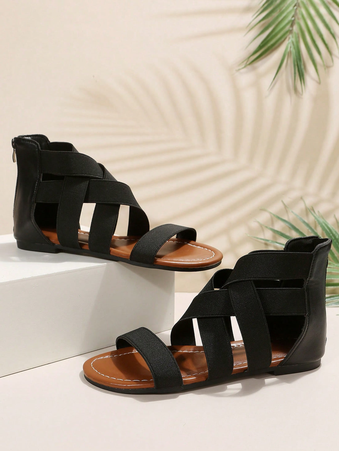 Pair of women’s floral beaded Roman style flat gladiator sandals with open toe design, suitable for beach and vacation wear.