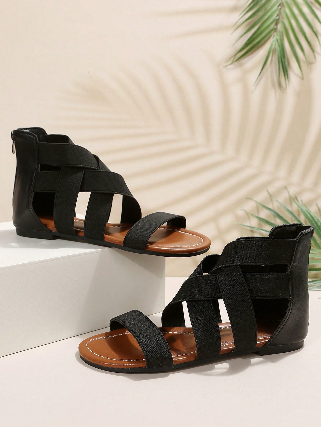 Pair of women’s floral beaded Roman style flat gladiator sandals with open toe design, suitable for beach and vacation wear.