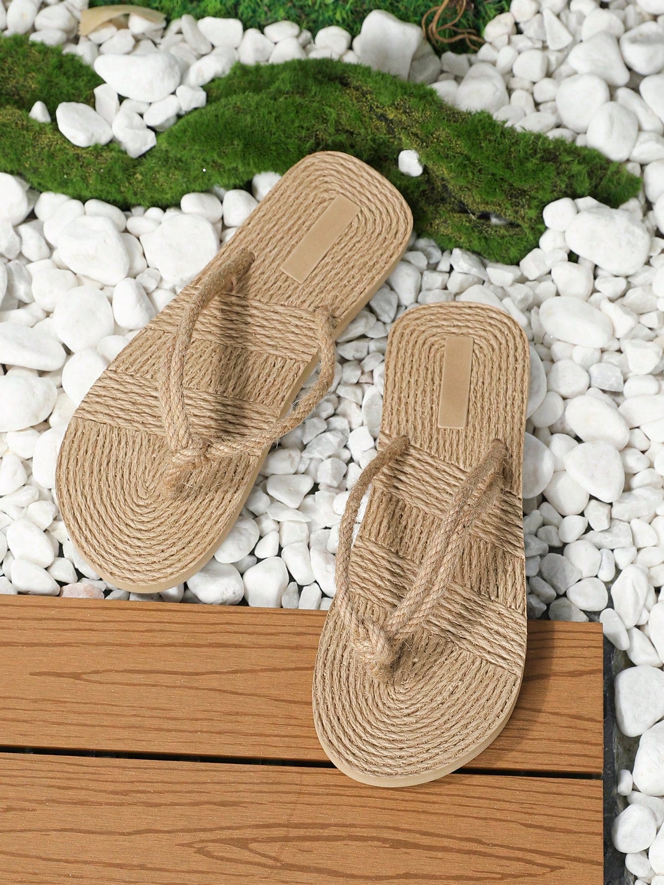 Pair of women's flat woven-look slippers with rope detail, designed for casual outdoor and beachside wear.
