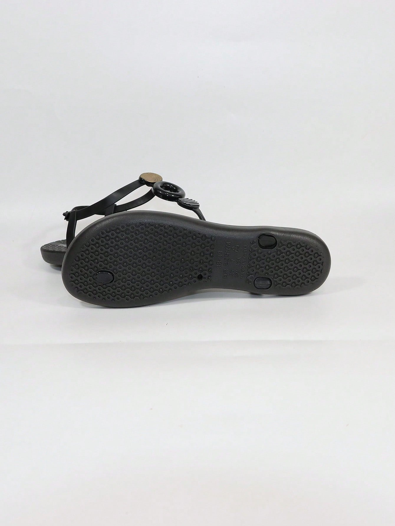 Black women's flat thong sandals with toe post and rhinestone embellishment, slip-on beach flip flop style.