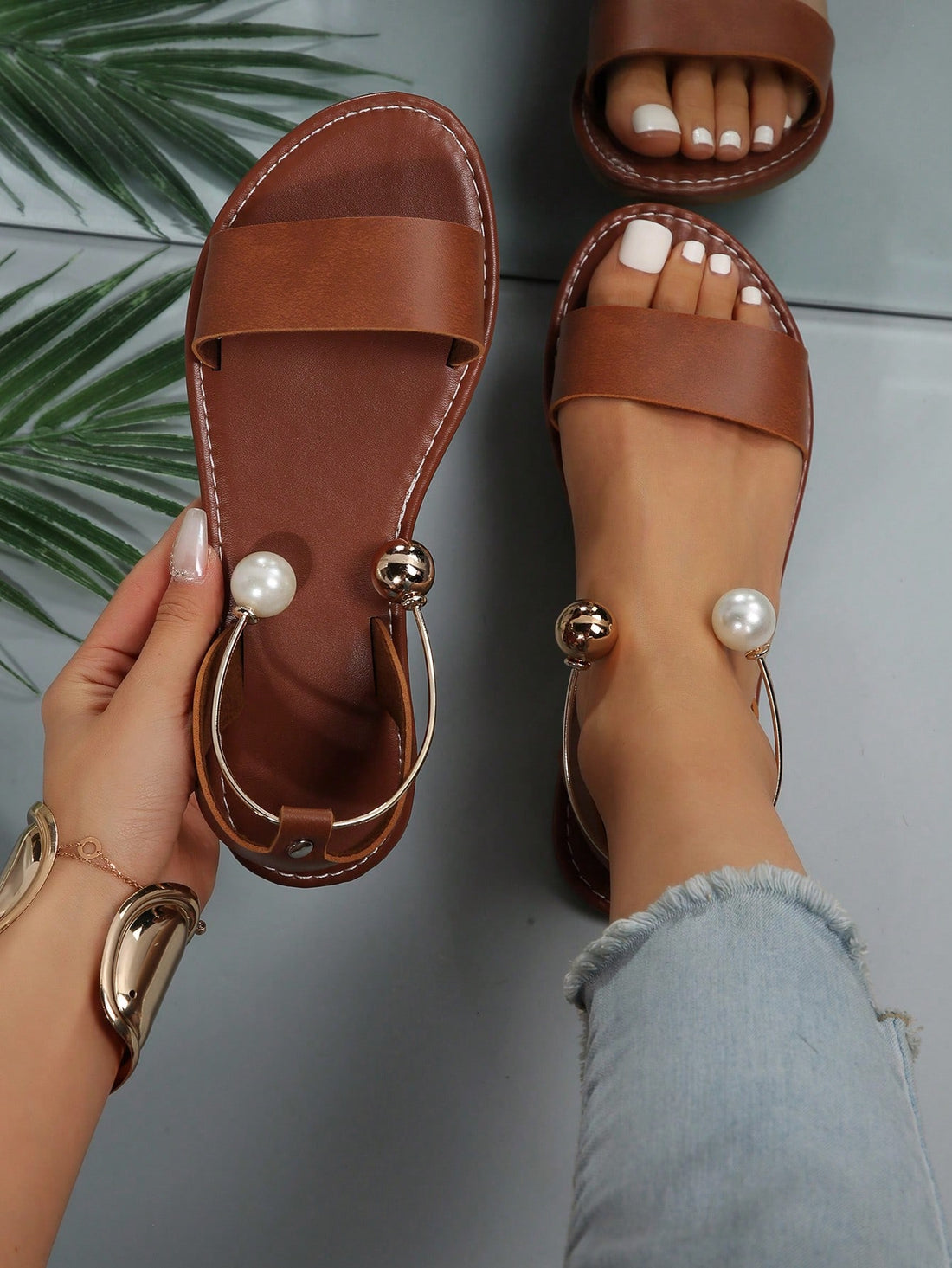 Women’s flat open-toe sandals with faux pearl decor and ankle strap design, featuring a microfiber leather upper and beach-ready fashion style.