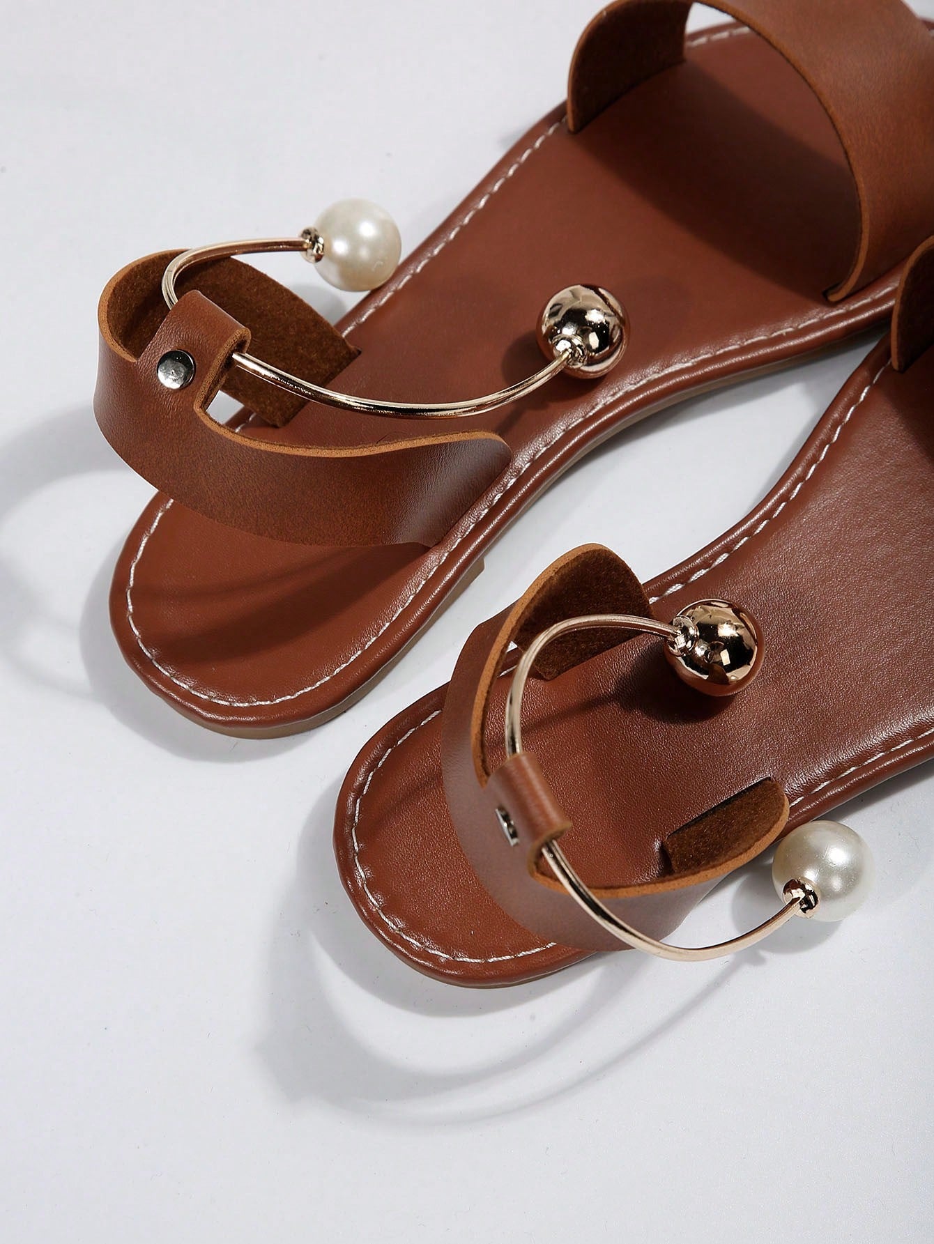 Women’s flat open-toe sandals with faux pearl decor and ankle strap design, featuring a microfiber leather upper and beach-ready fashion style.