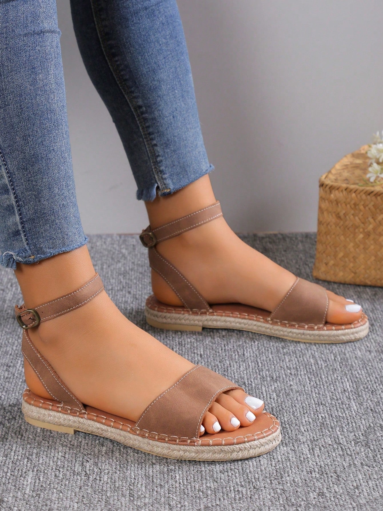 Women's woven Roman slide sandals with buckle detail, flat sole, and open-toe design for casual outdoor wear.