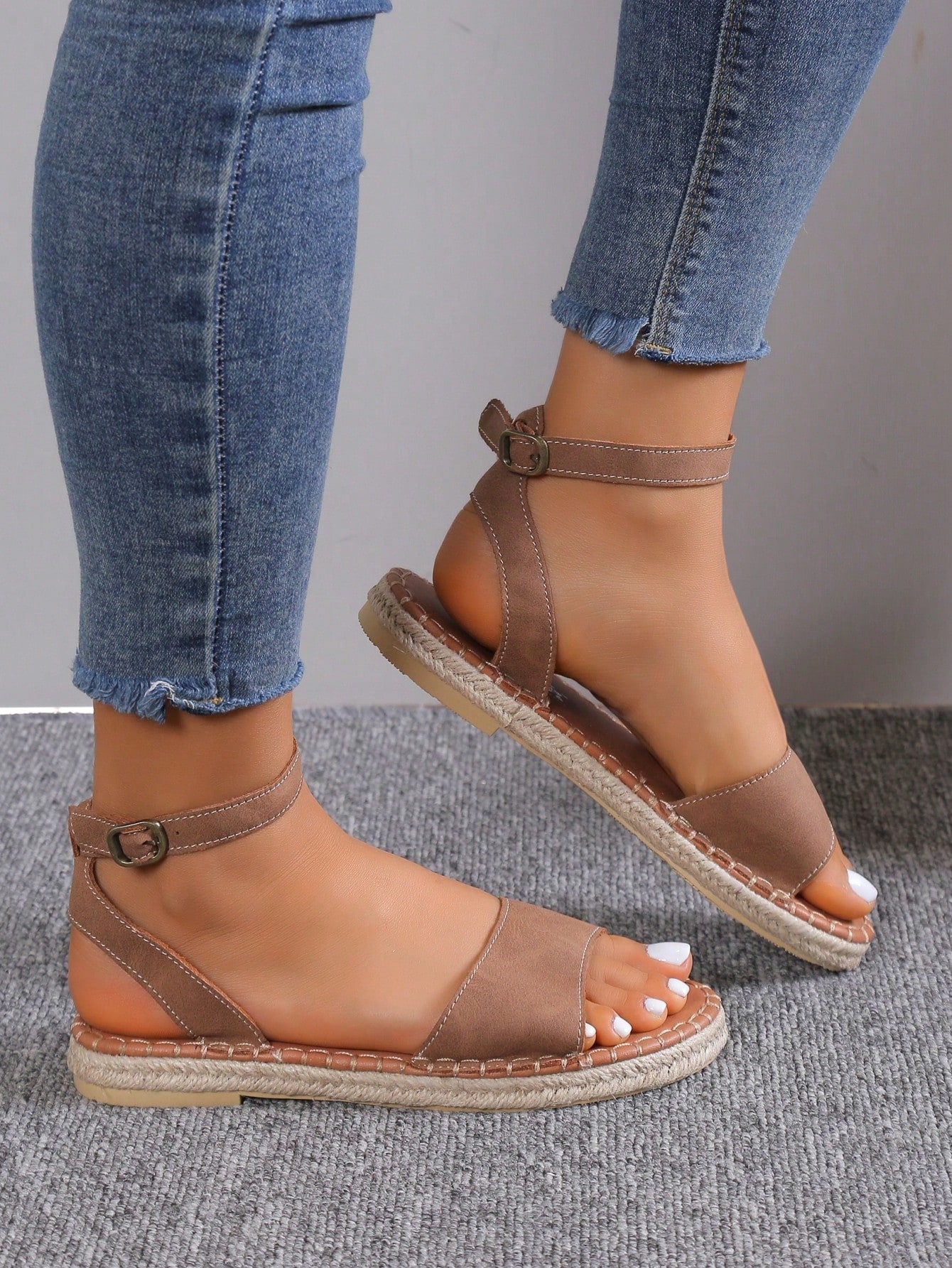 Women's woven Roman slide sandals with buckle detail, flat sole, and open-toe design for casual outdoor wear.
