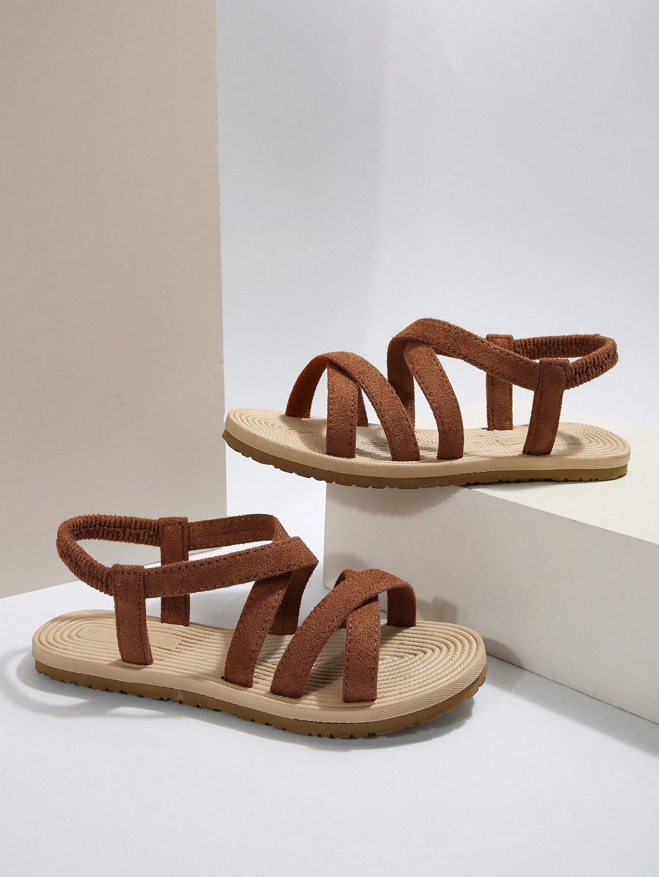 Women’s flat open-toe slide sandals with criss-cross woven straps and a plain casual design for daily, beach, and summer outdoor wear.