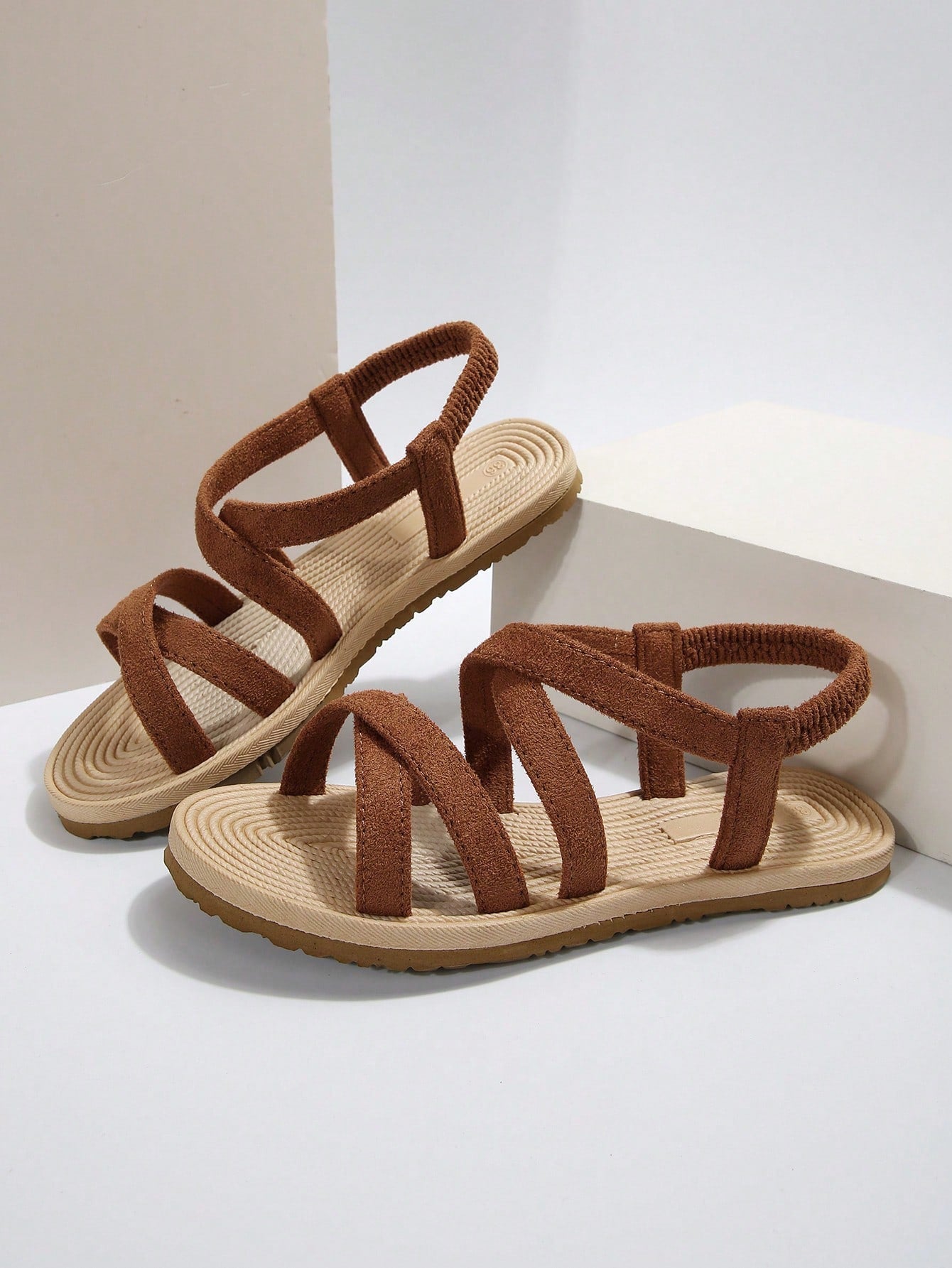 Women’s flat open-toe slide sandals with criss-cross woven straps and a plain casual design for daily, beach, and summer outdoor wear.