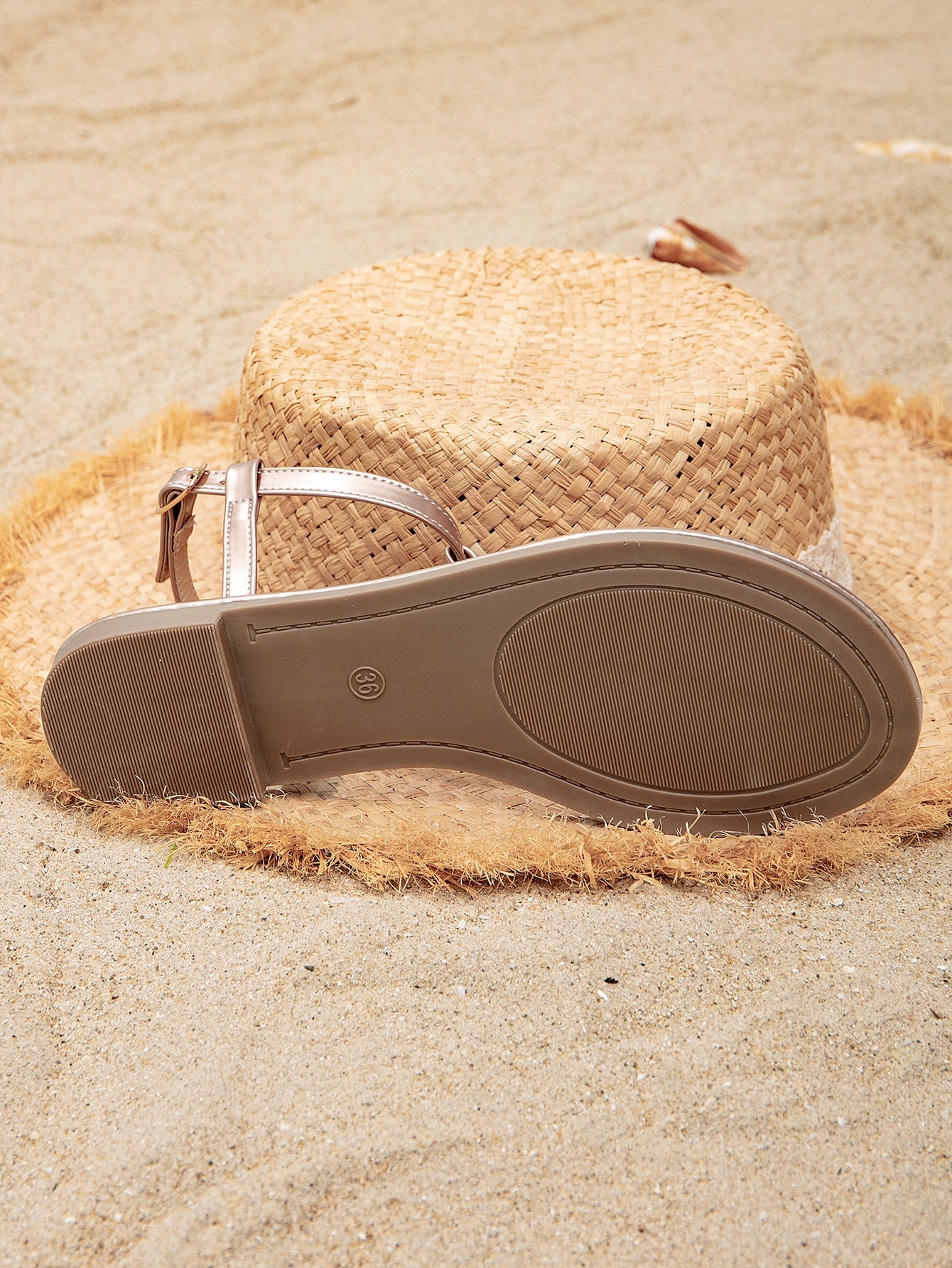 Pair of women’s gold flat sandals featuring a toe ring thong toe post design, criss-cross straps, and a slingback ankle strap.