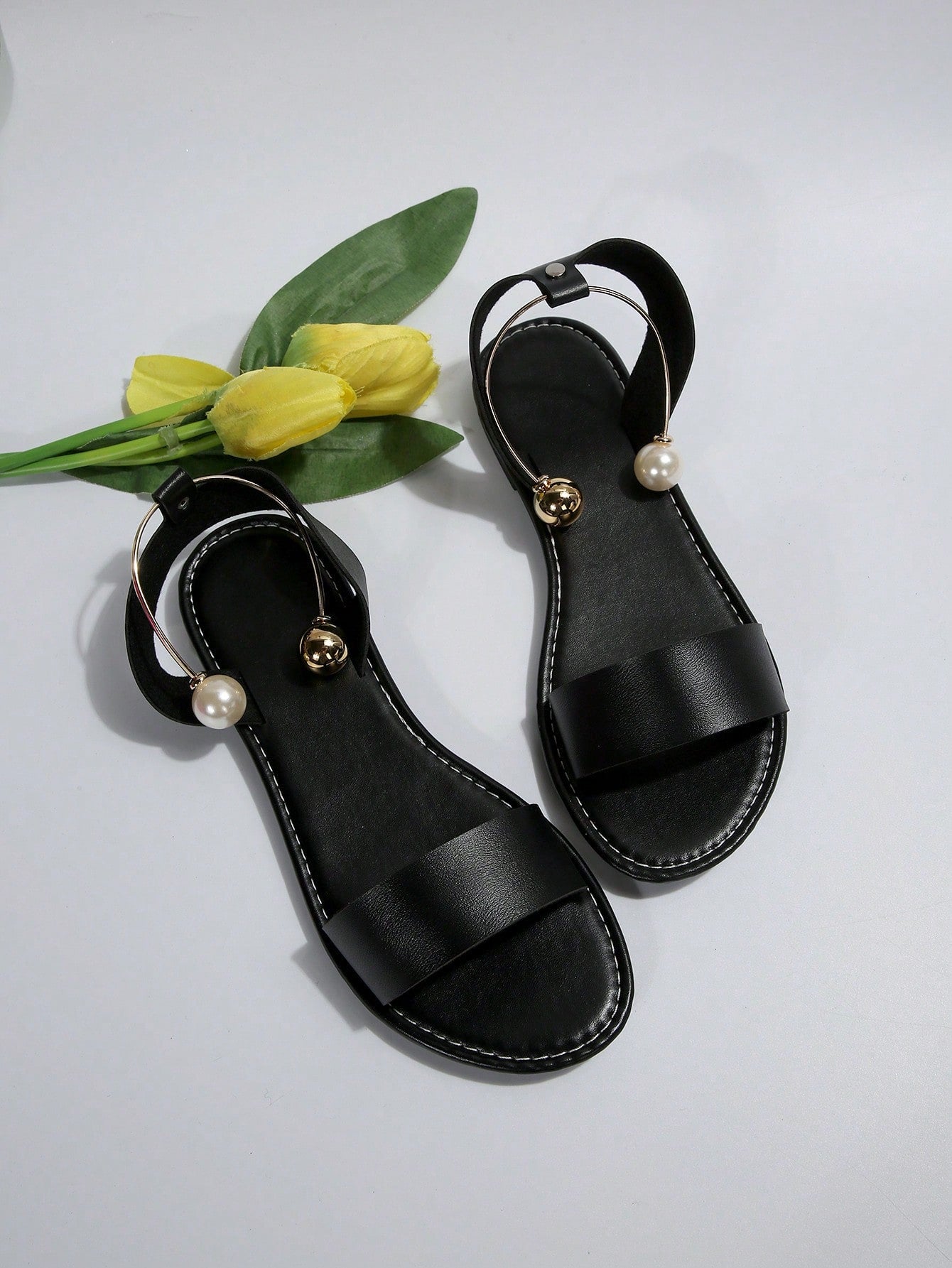 Women’s flat open-toe sandals with faux pearl decor and ankle strap design, featuring a microfiber leather upper and beach-ready fashion style.