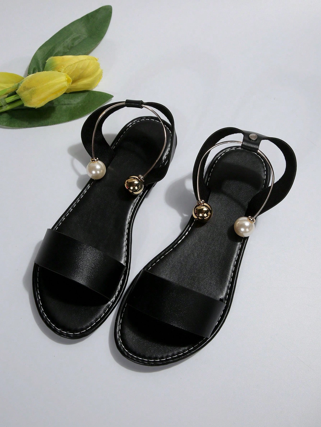 Women’s flat open-toe sandals with faux pearl decor and ankle strap design, featuring a microfiber leather upper and beach-ready fashion style.