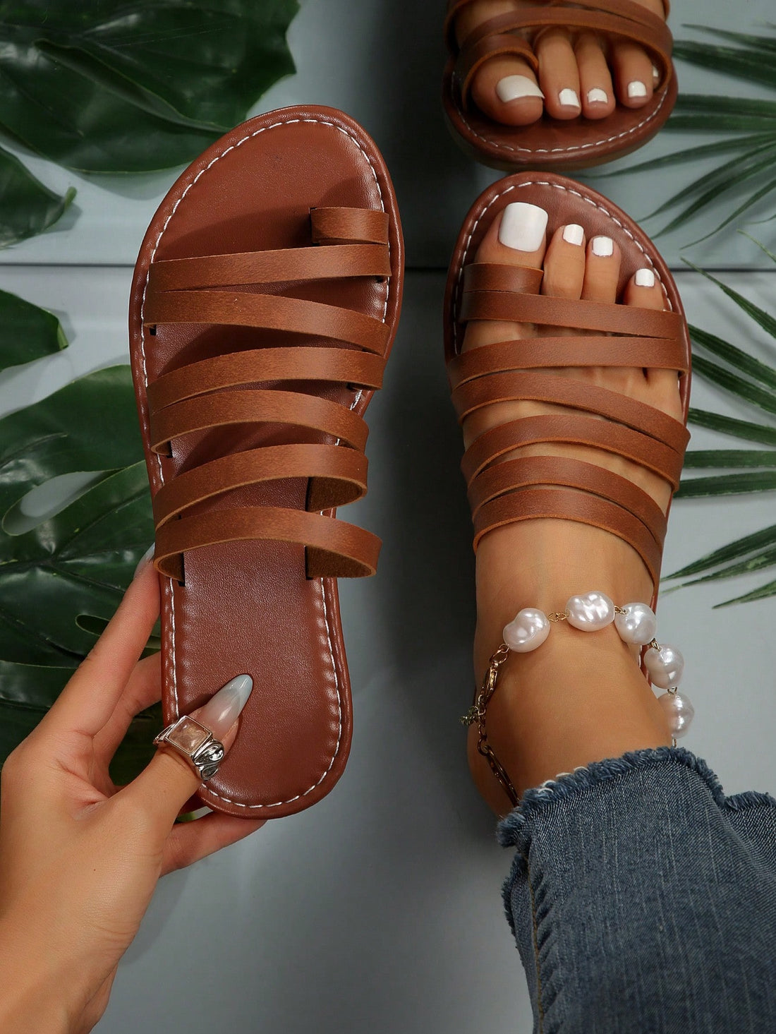 Women’s brown flat sandals with toe post and cross-over straps in a bohemian slide style