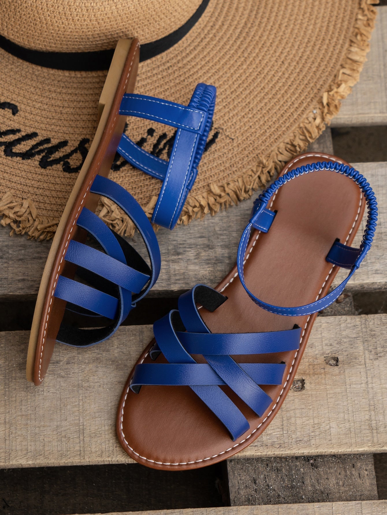 Blue women's flat slide sandals with crisscross straps, open toe, and elastic heel strap, featuring a PU leather upper and non-slip TPR sole for casual beach and outdoor wear.