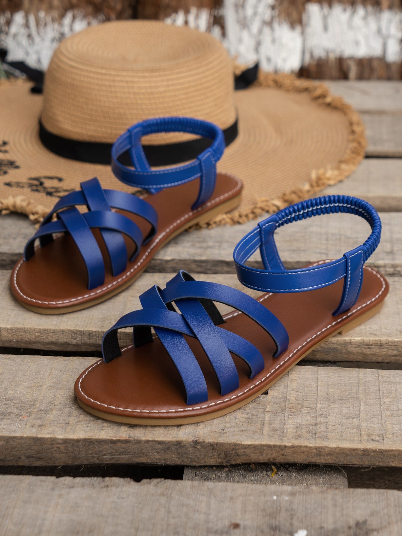 Blue women's flat slide sandals with crisscross straps, open toe, and elastic heel strap, featuring a PU leather upper and non-slip TPR sole for casual beach and outdoor wear.