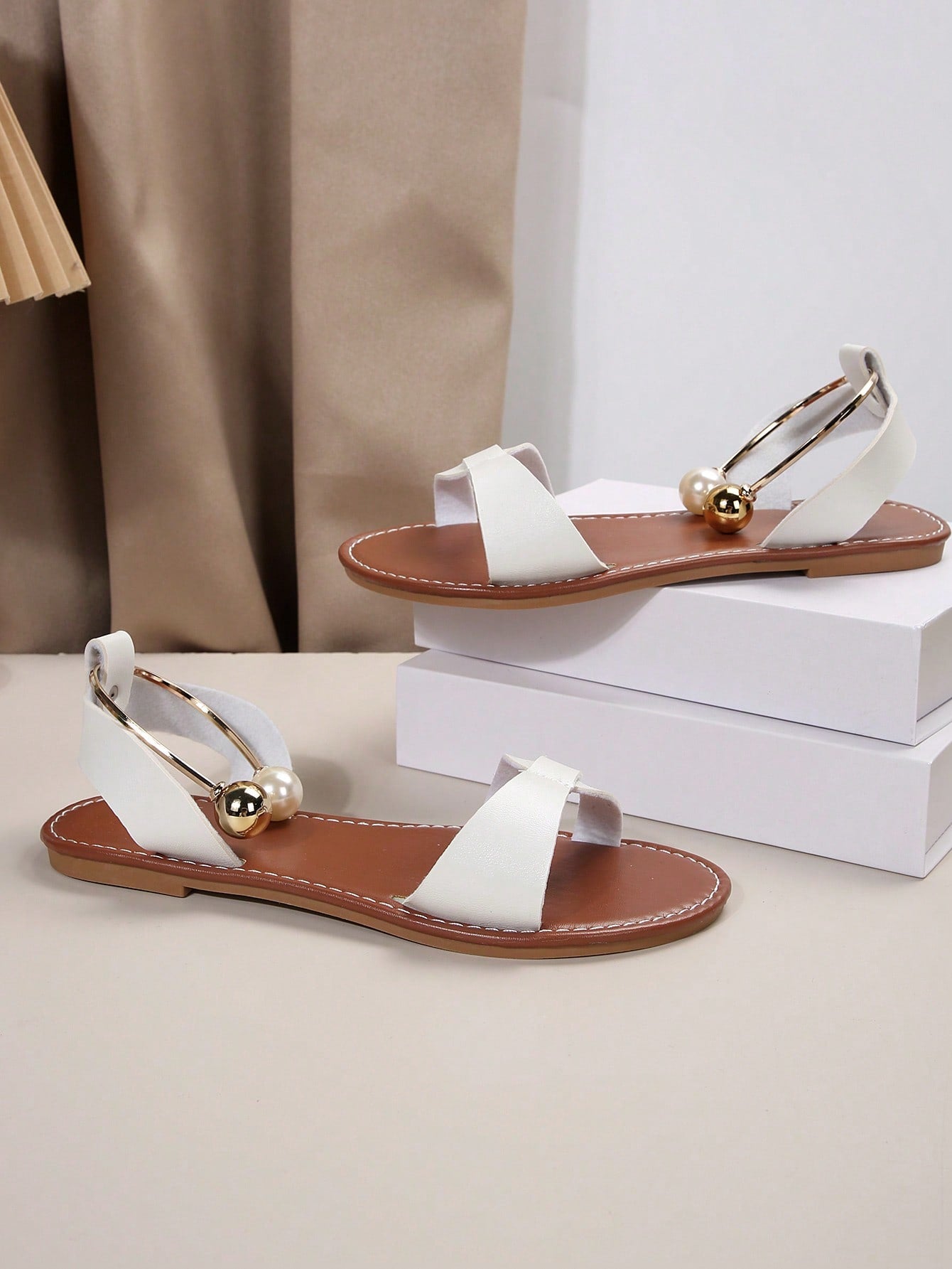 Women’s flat open-toe sandals with faux pearl decor and ankle strap design, featuring a microfiber leather upper and beach-ready fashion style.