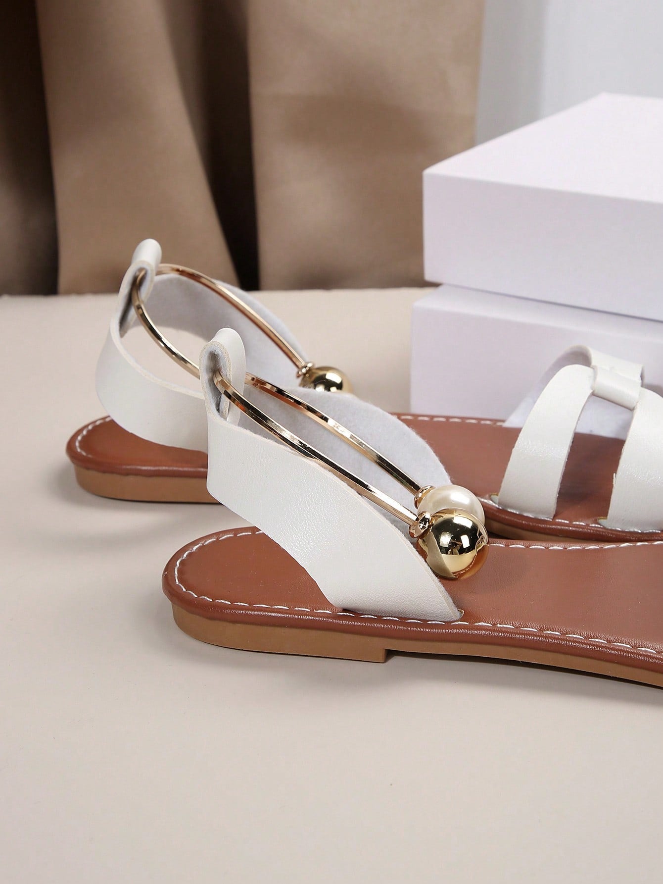 Women’s flat open-toe sandals with faux pearl decor and ankle strap design, featuring a microfiber leather upper and beach-ready fashion style.