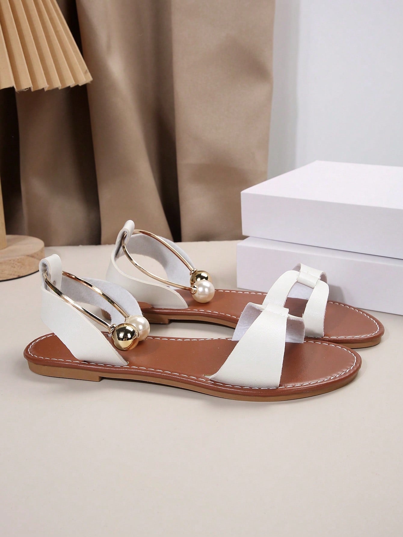 Women’s flat open-toe sandals with faux pearl decor and ankle strap design, featuring a microfiber leather upper and beach-ready fashion style.