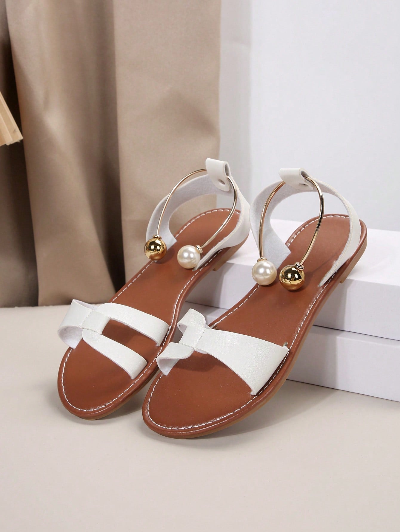Women’s flat open-toe sandals with faux pearl decor and ankle strap design, featuring a microfiber leather upper and beach-ready fashion style.