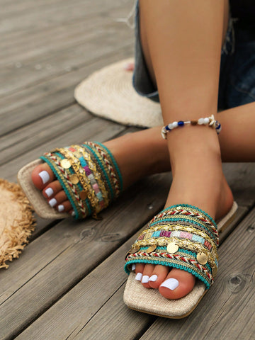 Pair of green women’s flat slide sandals with open toes, embroidered and beaded detailing, and fringe accents in a vacation style.