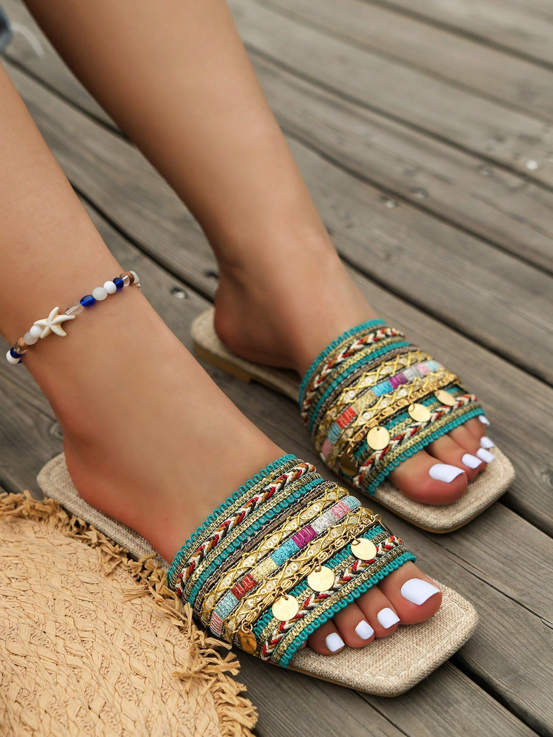 Pair of green women’s flat slide sandals with open toes, embroidered and beaded detailing, and fringe accents in a vacation style.