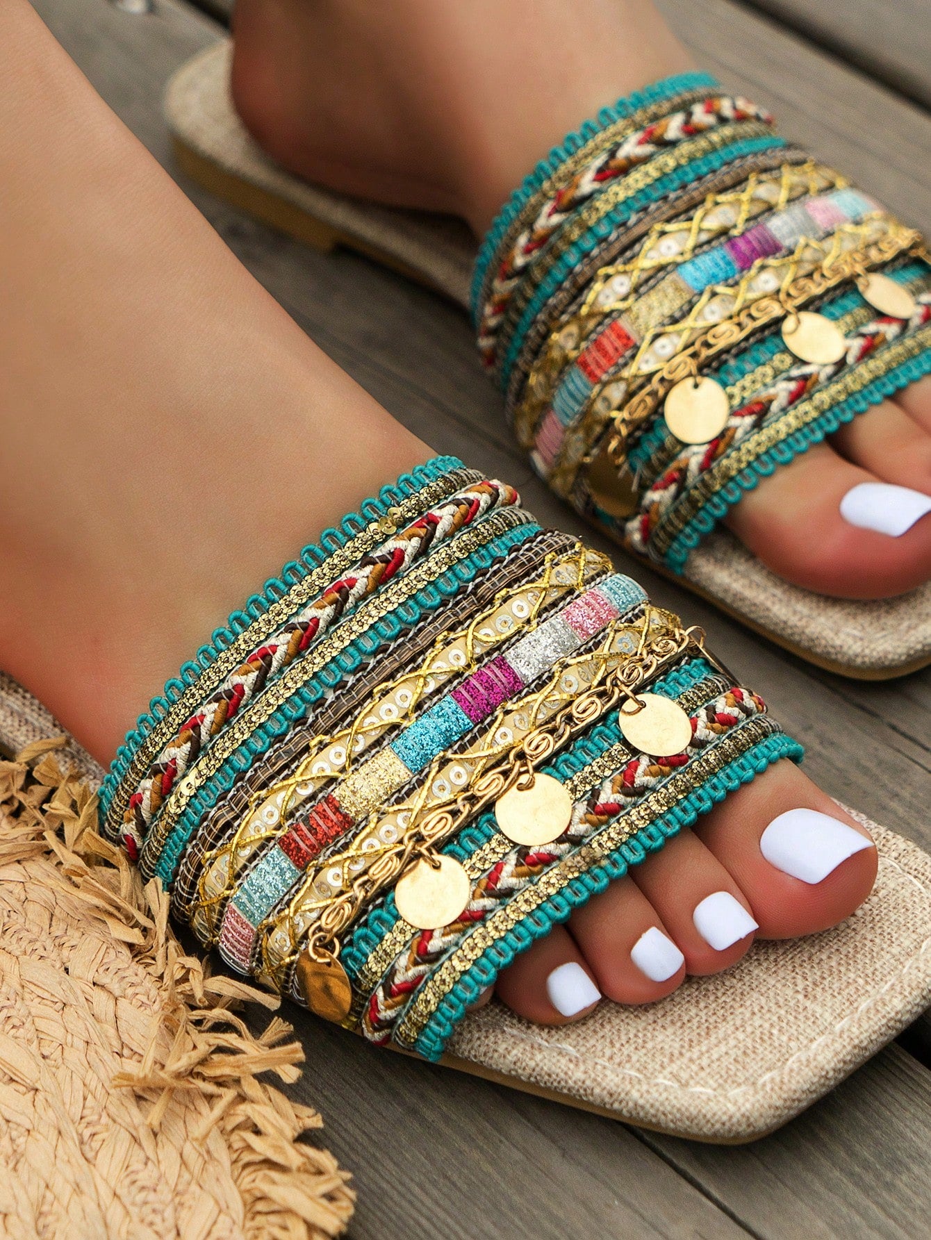 Pair of green women’s flat slide sandals with open toes, embroidered and beaded detailing, and fringe accents in a vacation style.