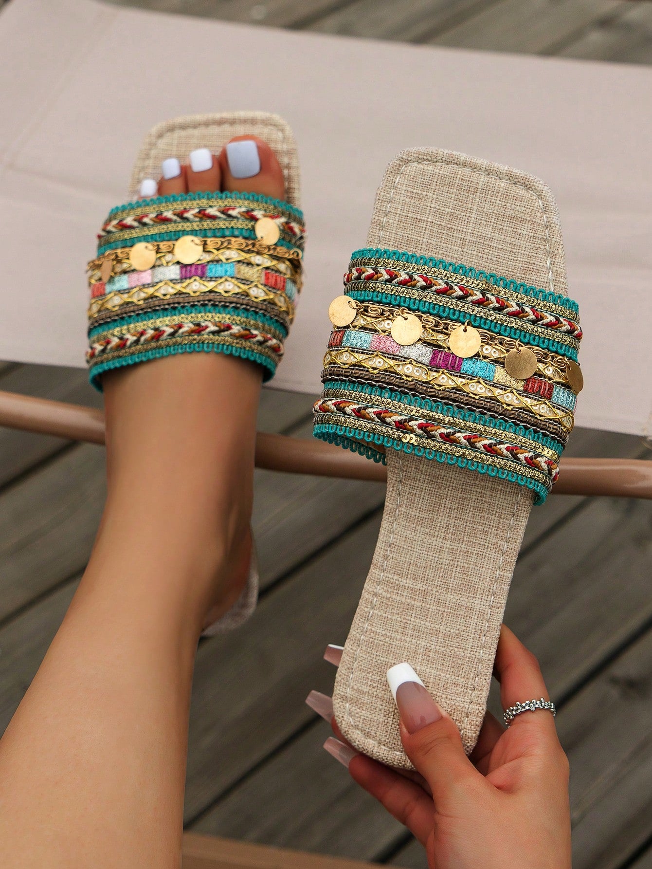Pair of green women’s flat slide sandals with open toes, embroidered and beaded detailing, and fringe accents in a vacation style.