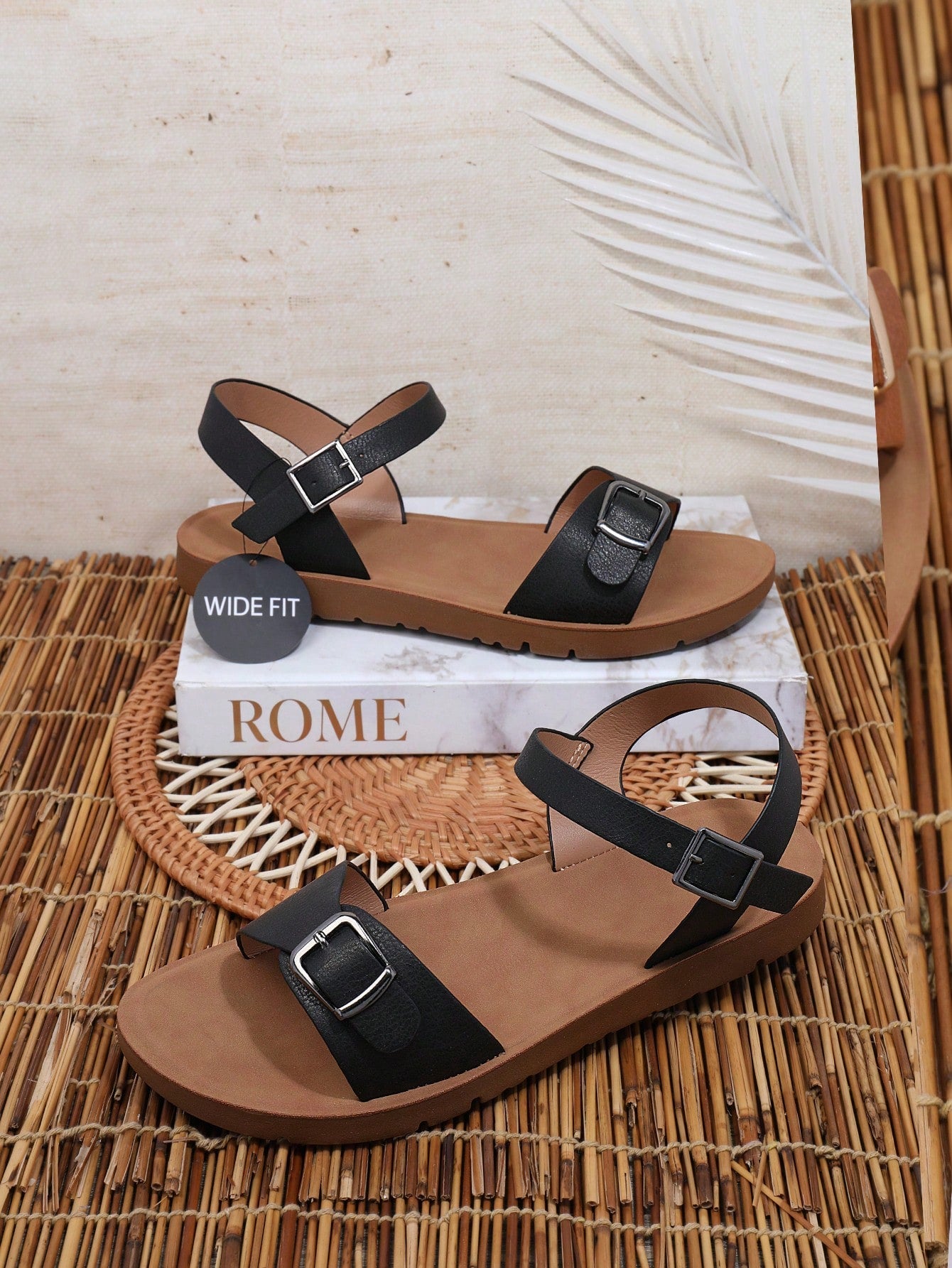 Women’s wide fit flat sandals with an open toe, plain design, and buckle detail, suitable for casual beach and vacation wear.