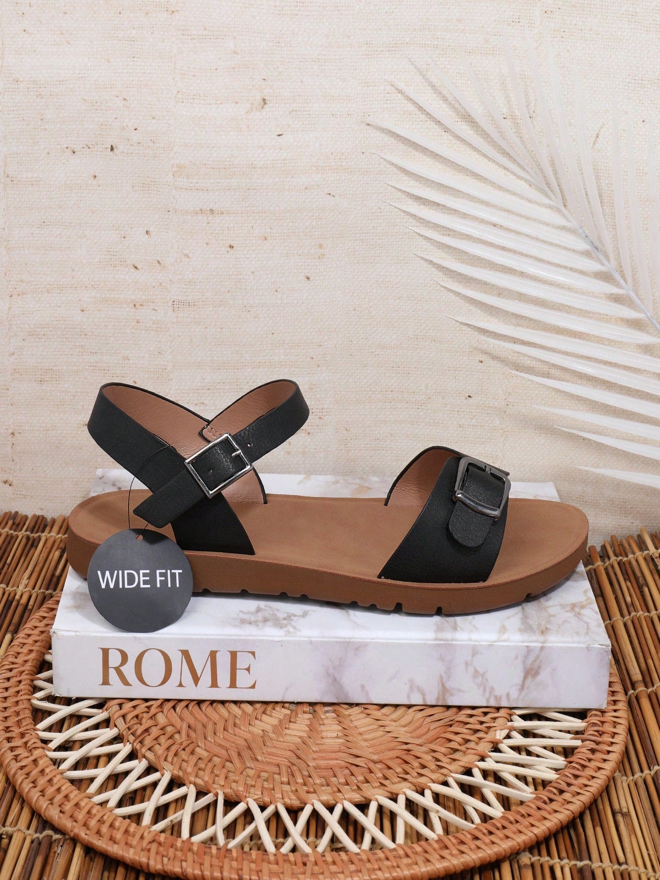 Women’s wide fit flat sandals with an open toe, plain design, and buckle detail, suitable for casual beach and vacation wear.