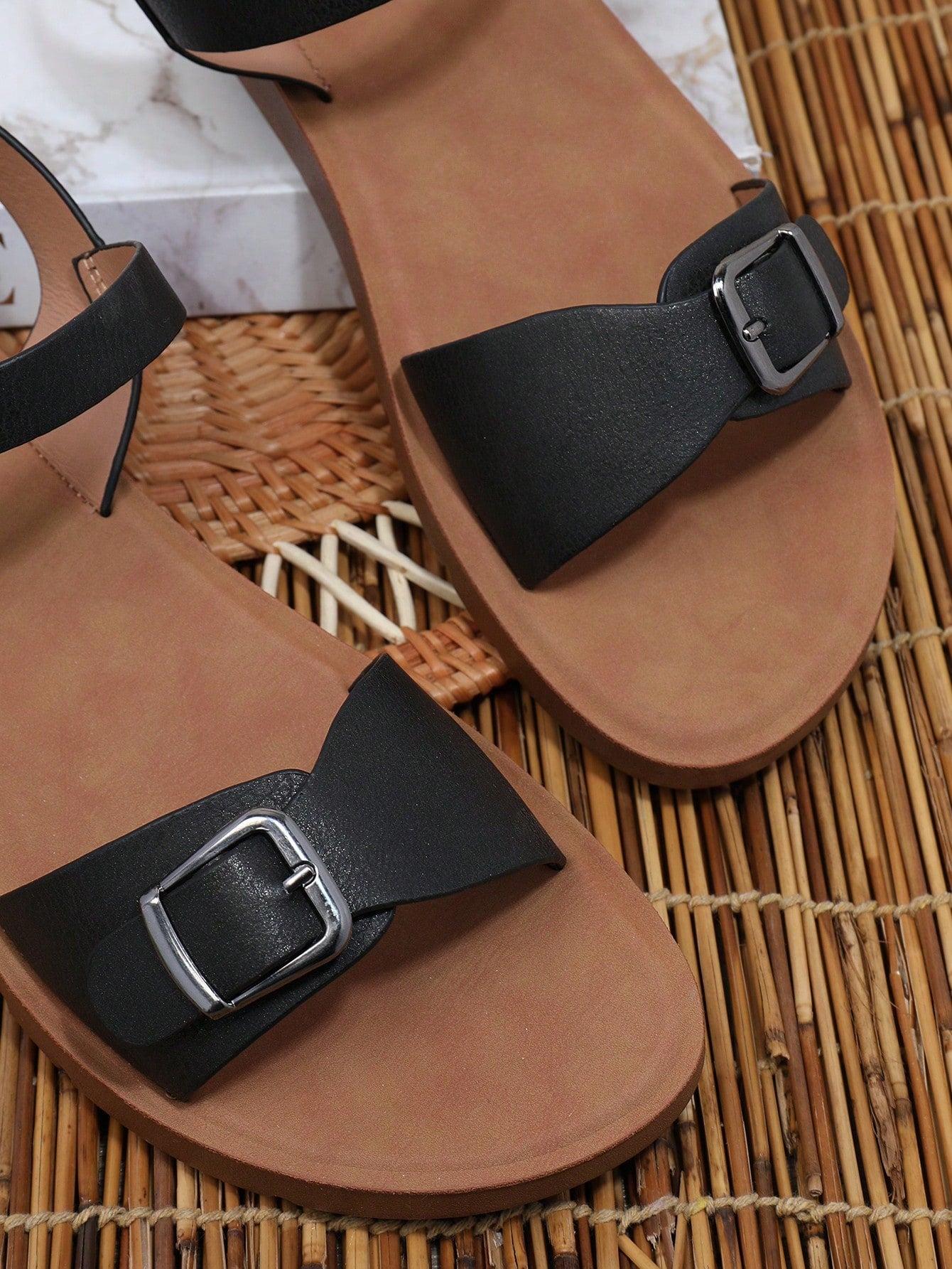 Women’s wide fit flat sandals with an open toe, plain design, and buckle detail, suitable for casual beach and vacation wear.