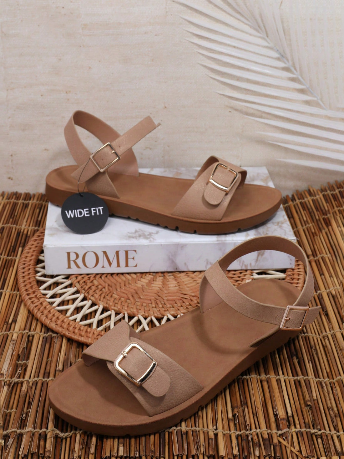 Women’s wide fit flat sandals with an open toe, plain design, and buckle detail, suitable for casual beach and vacation wear.