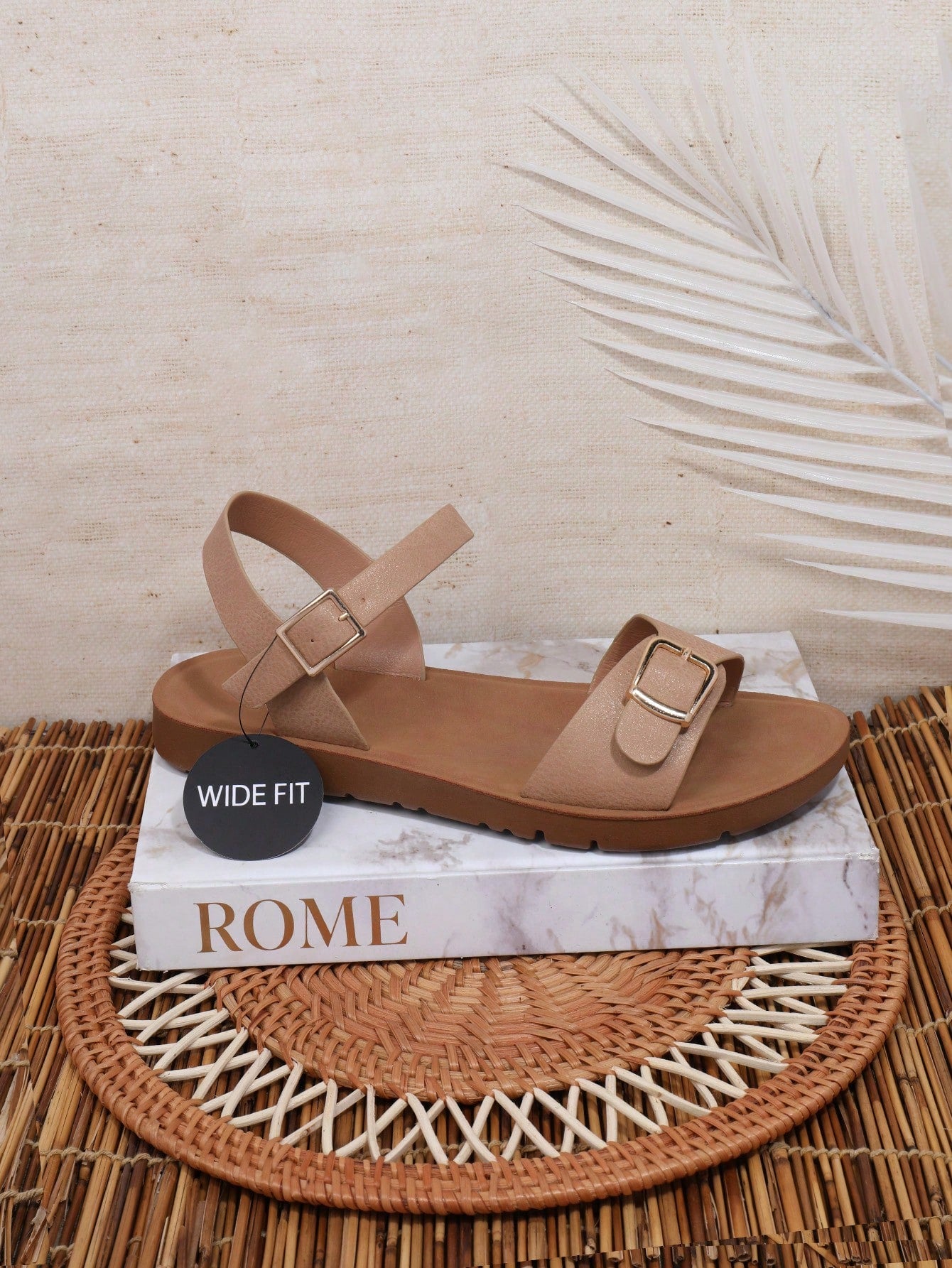 Women’s wide fit flat sandals with an open toe, plain design, and buckle detail, suitable for casual beach and vacation wear.