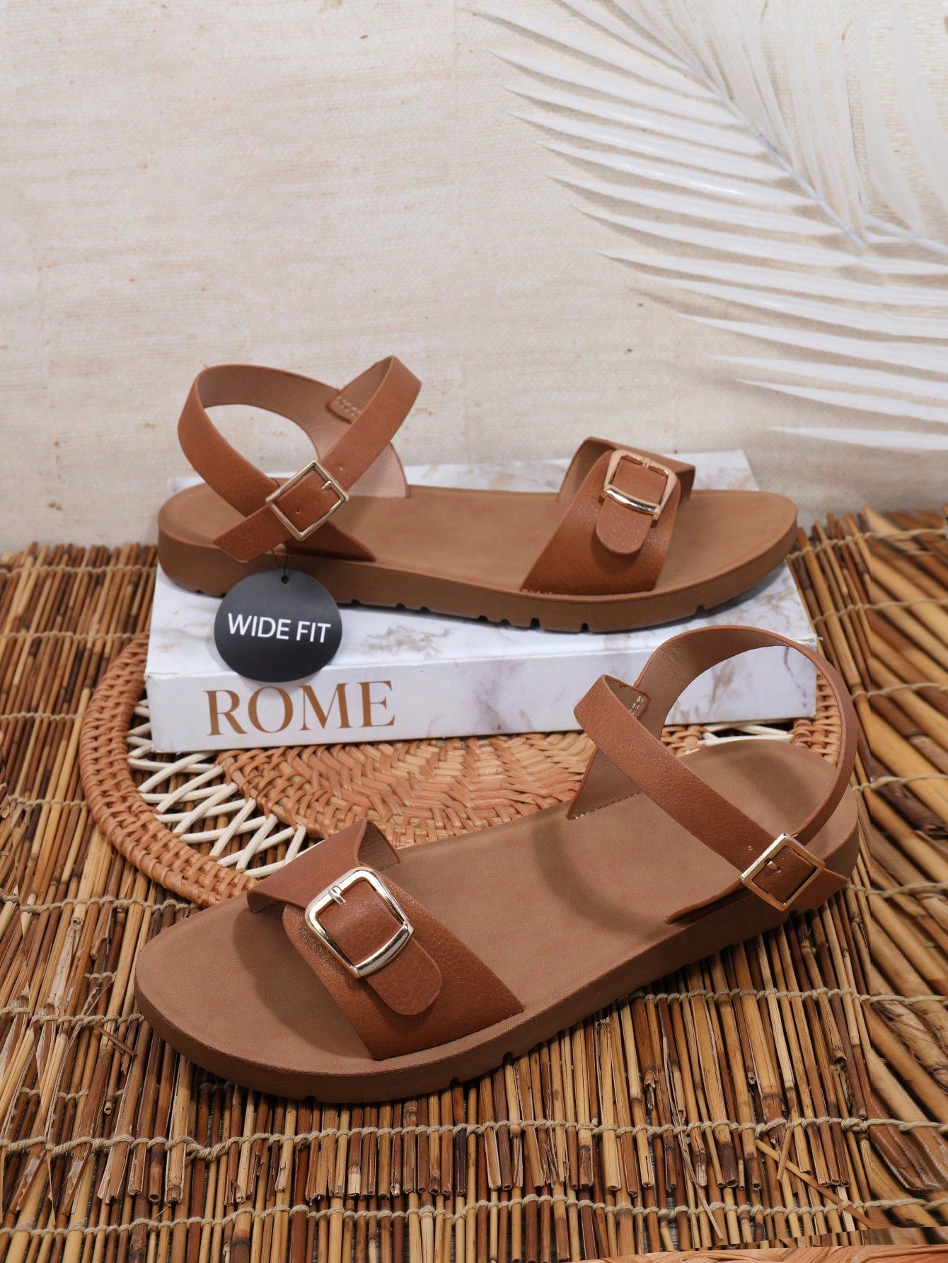 Women’s wide fit flat sandals with an open toe, plain design, and buckle detail, suitable for casual beach and vacation wear.