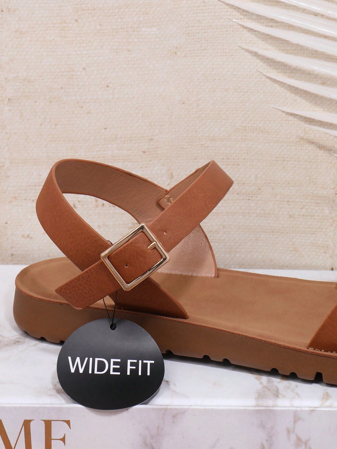 Women’s wide fit flat sandals with an open toe, plain design, and buckle detail, suitable for casual beach and vacation wear.