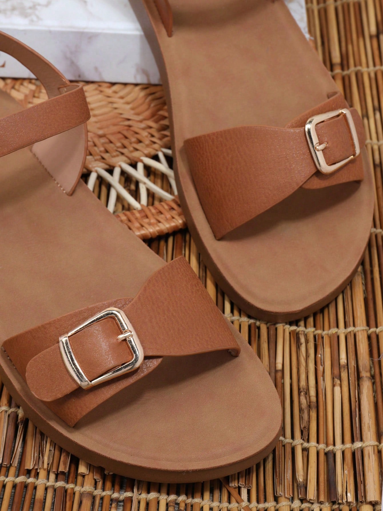 Women’s wide fit flat sandals with an open toe, plain design, and buckle detail, suitable for casual beach and vacation wear.