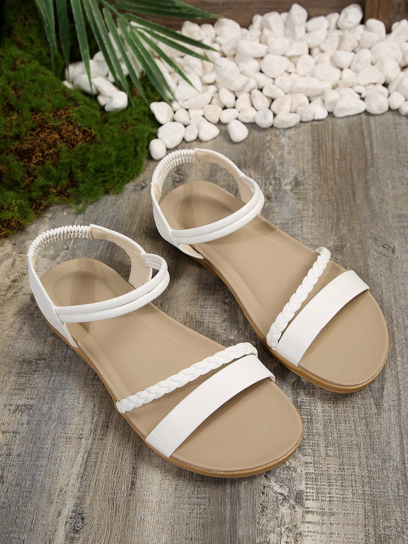 Women’s flat gladiator sandals with braided detail and an open-toe design, suitable for beach and outdoor wear.
