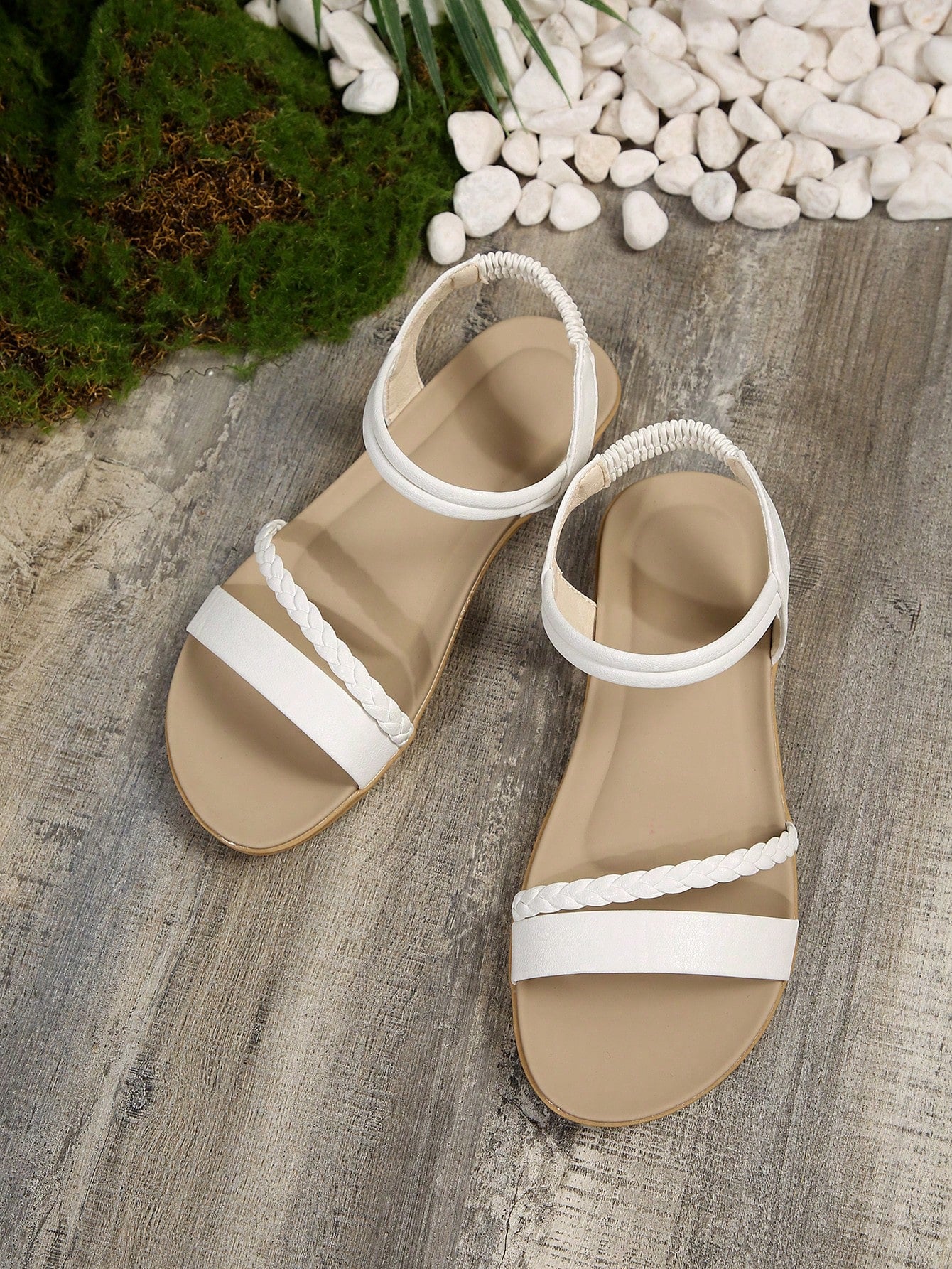 Women’s flat gladiator sandals with braided detail and an open-toe design, suitable for beach and outdoor wear.