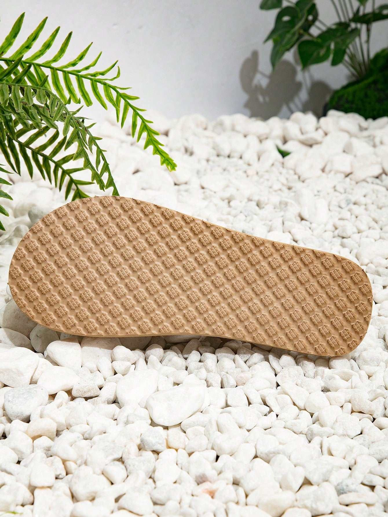 Women’s khaki flat flip-flop sandal with woven braided pattern and casual beach style.